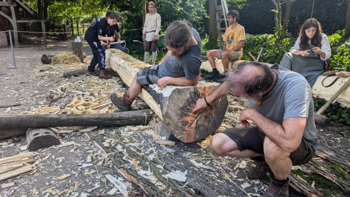 PreHistorisch Dorp volunteers go back in time and carve a canoe from a tree trunk